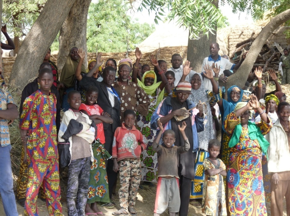 Habitants du village regroupés qui saluent de la main